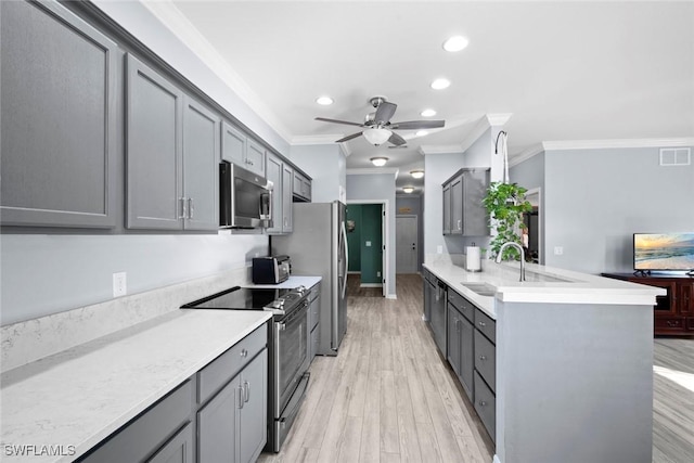 kitchen featuring ornamental molding, stainless steel appliances, gray cabinetry, and light hardwood / wood-style floors