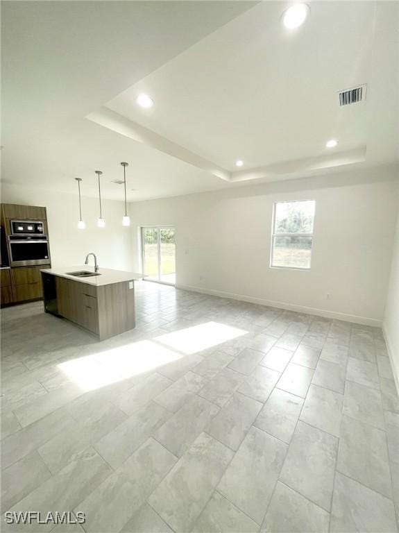 interior space with a tray ceiling and sink