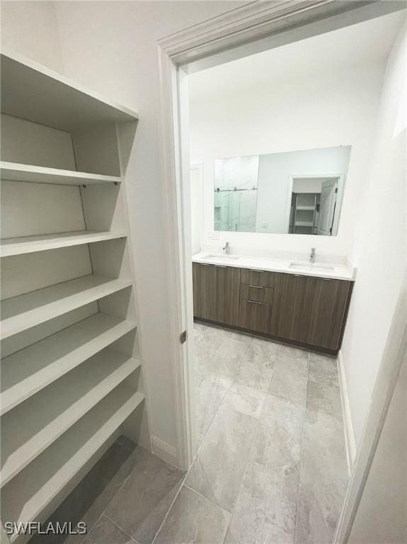 bathroom featuring a shower with door and vanity