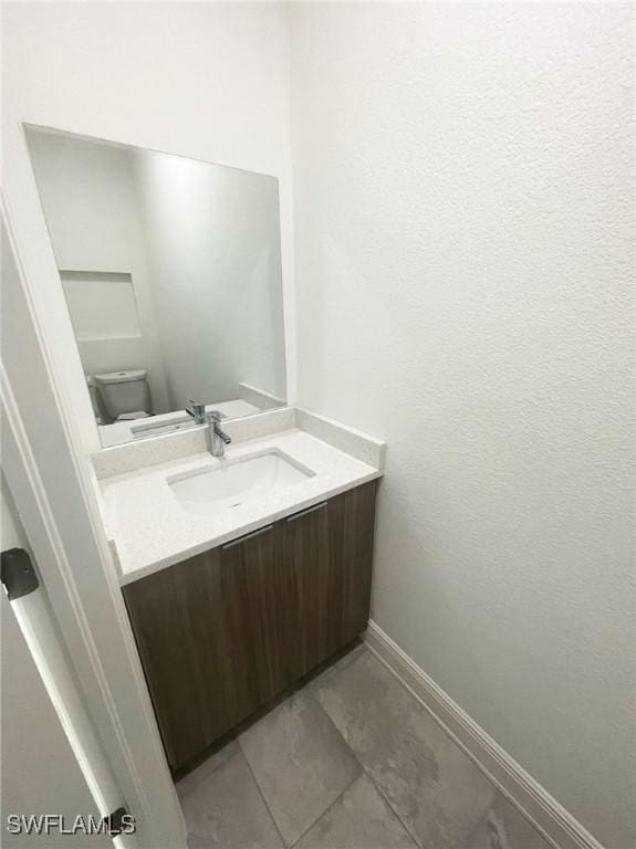 bathroom featuring tile patterned flooring, vanity, and toilet