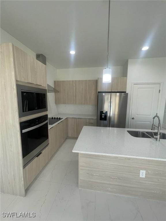 kitchen featuring decorative light fixtures, light brown cabinets, sink, and appliances with stainless steel finishes