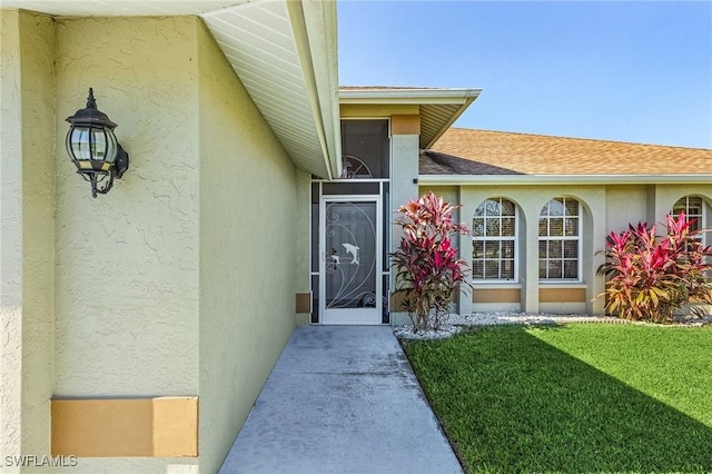 entrance to property featuring a lawn