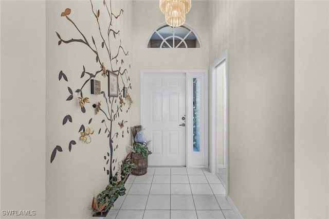 tiled entryway with a chandelier and a towering ceiling