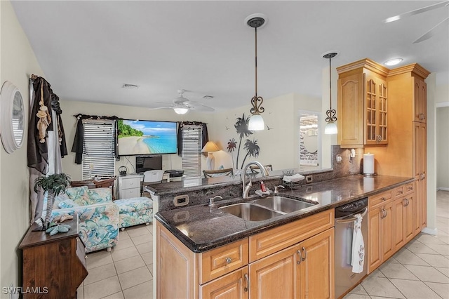 kitchen featuring pendant lighting, sink, stainless steel dishwasher, ceiling fan, and dark stone countertops