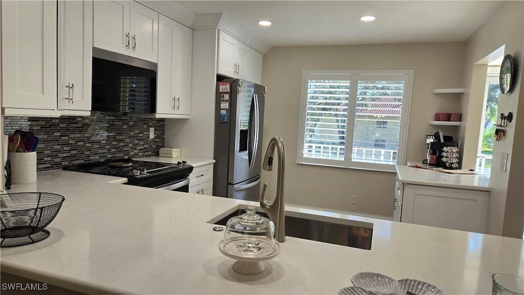 kitchen featuring white cabinets, decorative backsplash, sink, stainless steel fridge with ice dispenser, and stove