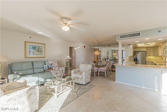 tiled living room with ceiling fan and sink