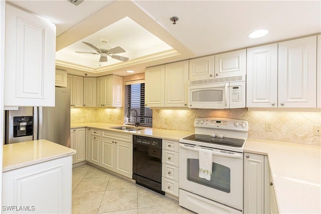 kitchen featuring ceiling fan, sink, white appliances, a tray ceiling, and light tile patterned floors