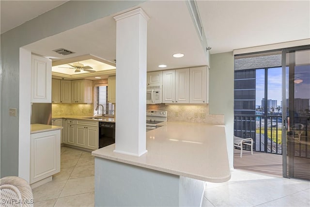 kitchen featuring white appliances, sink, ceiling fan, light tile patterned flooring, and kitchen peninsula