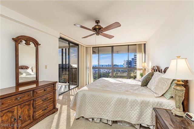 bedroom featuring access to exterior, light carpet, ceiling fan, and floor to ceiling windows