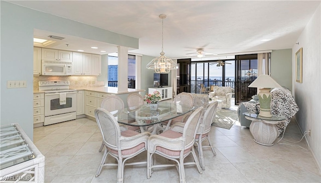 dining area with ceiling fan with notable chandelier and light tile patterned floors