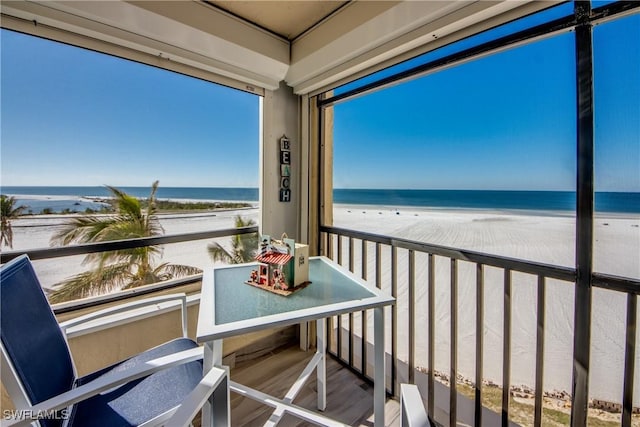 balcony featuring a water view and a beach view