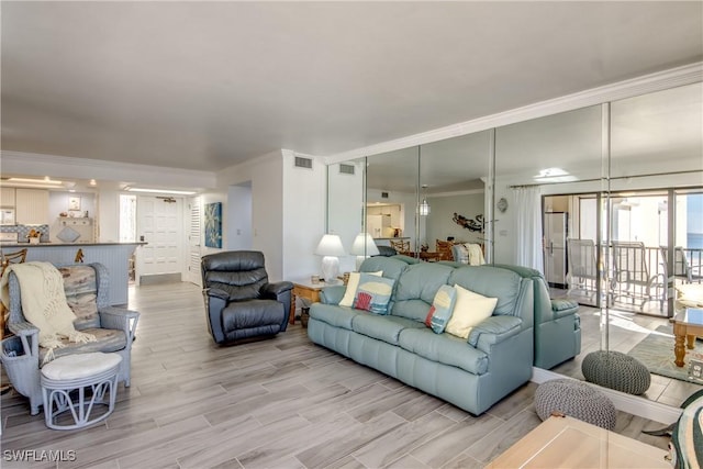 living room with light hardwood / wood-style flooring and crown molding