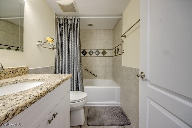 full bathroom with shower / bath combination with curtain, toilet, tile walls, and vanity