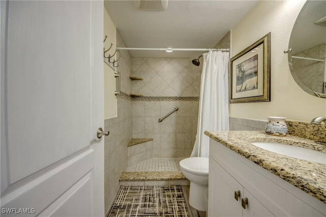 bathroom with a shower with curtain, vanity, toilet, and tile patterned floors