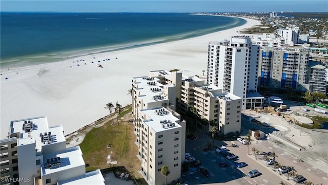 birds eye view of property with a water view and a beach view