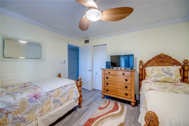 bedroom featuring ceiling fan, a closet, ornamental molding, and light hardwood / wood-style flooring