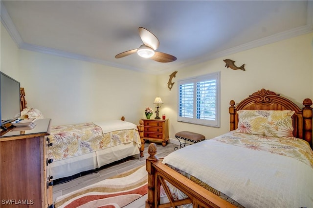 bedroom with light hardwood / wood-style floors, ceiling fan, and ornamental molding