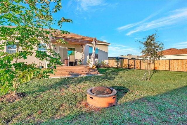 view of yard featuring a deck, a pergola, and an outdoor fire pit