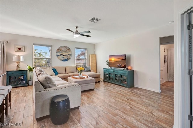 living room featuring ceiling fan and light hardwood / wood-style flooring