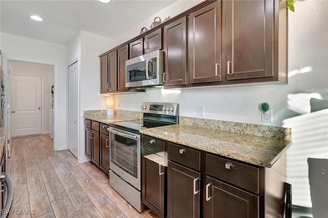 kitchen featuring light stone countertops, dark brown cabinets, stainless steel appliances, and light hardwood / wood-style floors