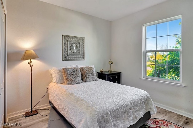 bedroom with multiple windows and light hardwood / wood-style flooring