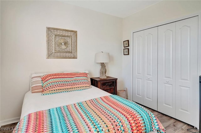 bedroom with light hardwood / wood-style floors and a closet