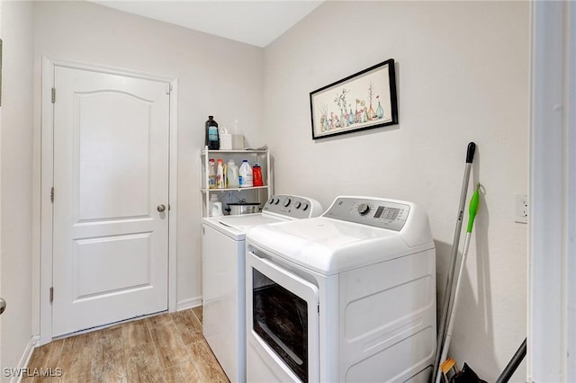 laundry area featuring washer and clothes dryer and light hardwood / wood-style floors