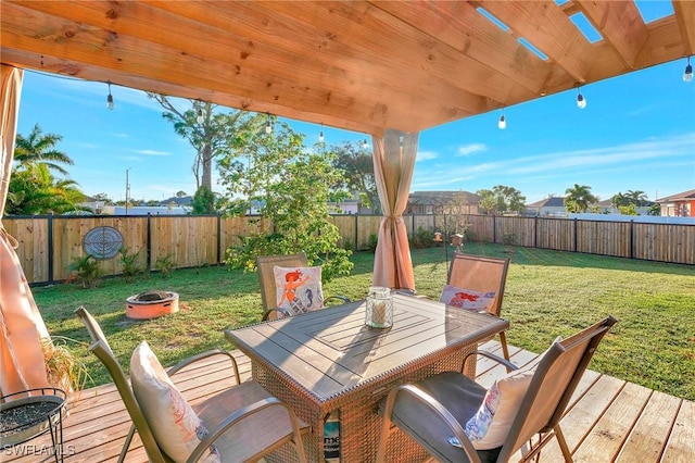 wooden deck with a yard and a fire pit