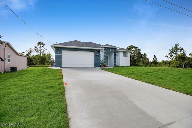 view of front of property with a front yard, central AC, and a garage