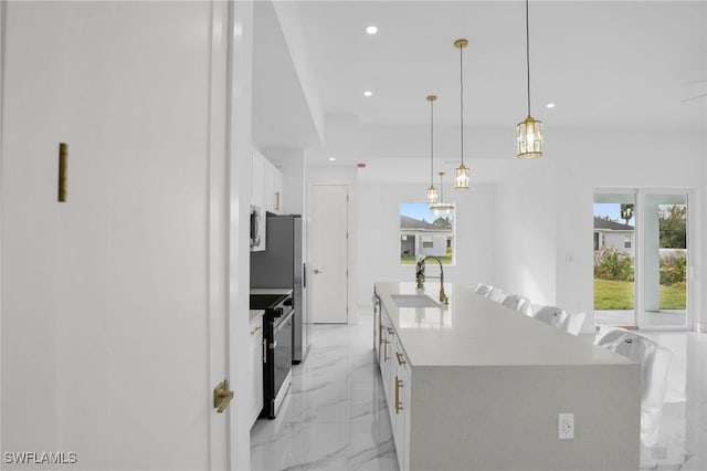 kitchen featuring sink, an island with sink, a wealth of natural light, white cabinetry, and stainless steel appliances