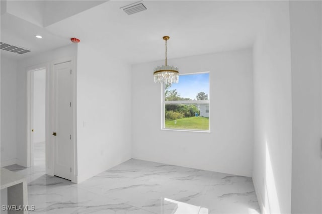 unfurnished room with a notable chandelier