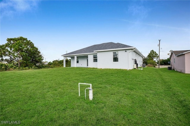 rear view of property featuring a lawn