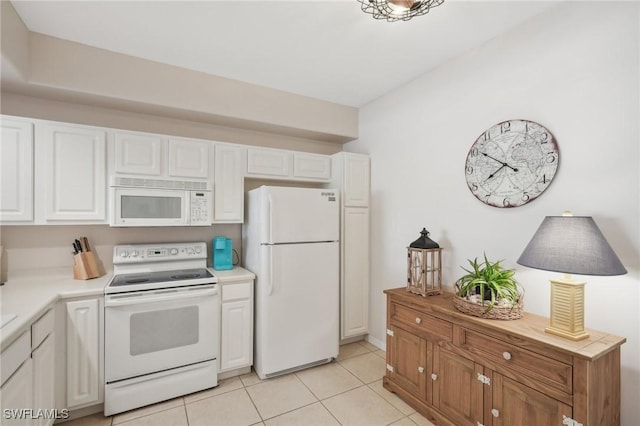 kitchen featuring white cabinetry, light tile patterned floors, and white appliances