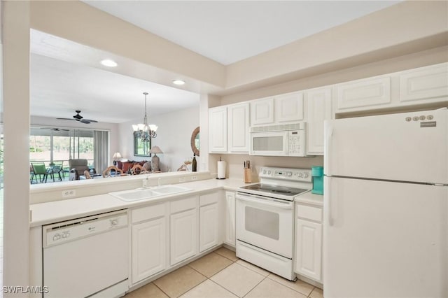 kitchen with light tile patterned flooring, sink, white appliances, ceiling fan with notable chandelier, and white cabinets