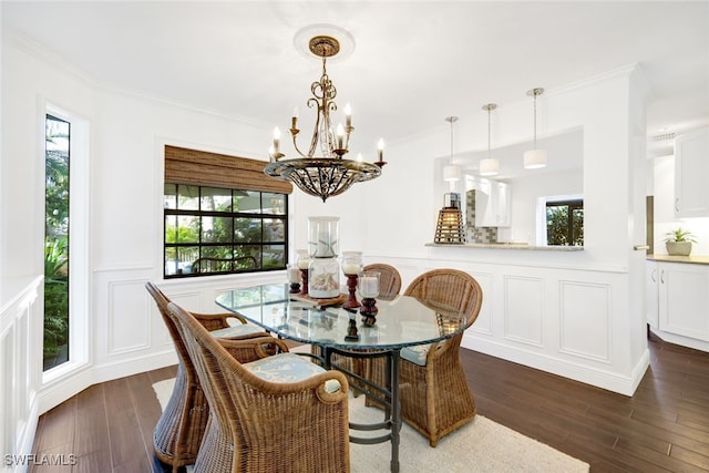 dining area with dark wood-type flooring, ornamental molding, and a wealth of natural light