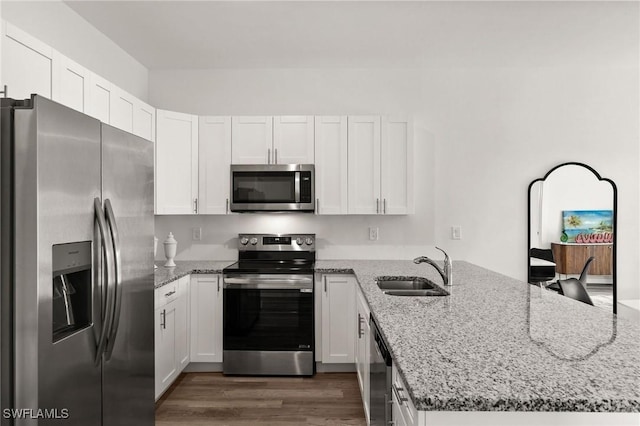 kitchen featuring dark wood-type flooring, white cabinets, sink, light stone counters, and stainless steel appliances