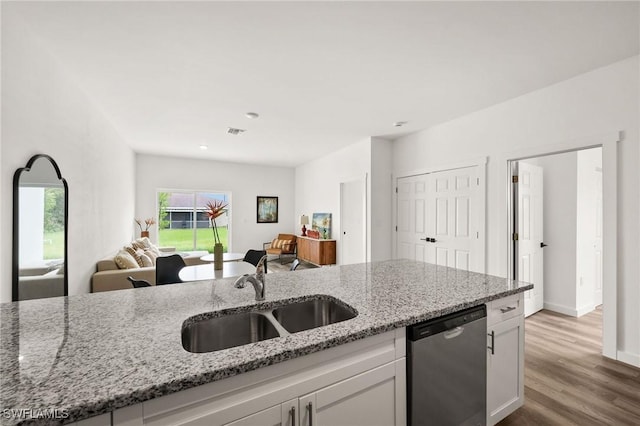 kitchen featuring light stone counters, sink, dishwasher, light hardwood / wood-style floors, and white cabinetry