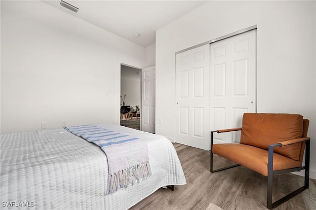 bedroom with hardwood / wood-style floors and a closet