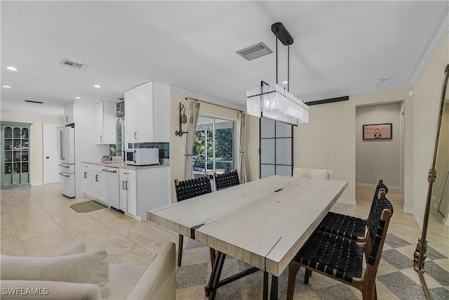 dining space featuring a chandelier, crown molding, and sink