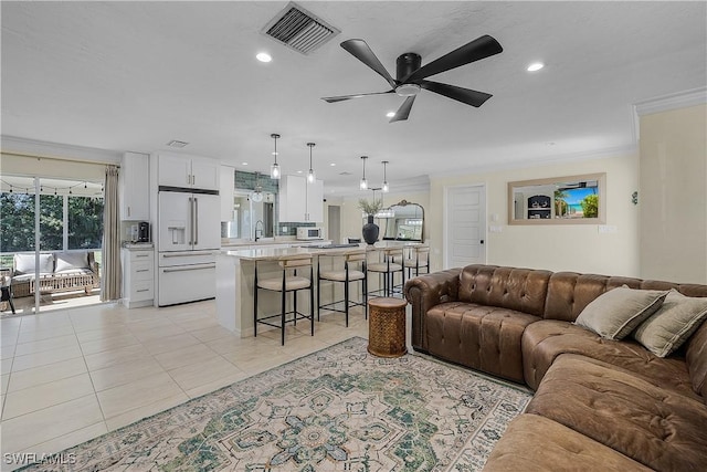 living room with crown molding, sink, ceiling fan, and light tile patterned floors