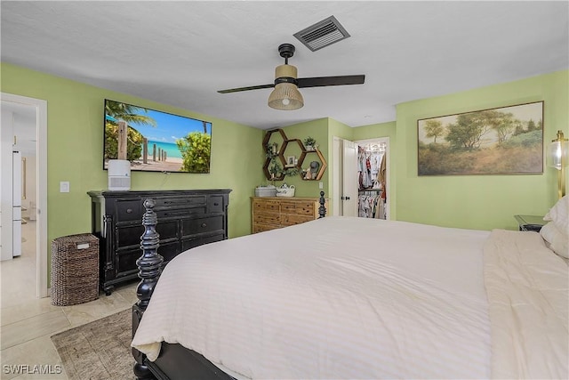 tiled bedroom with a walk in closet, a closet, and ceiling fan