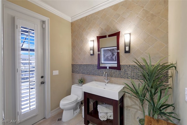 bathroom featuring vanity, toilet, a healthy amount of sunlight, and crown molding