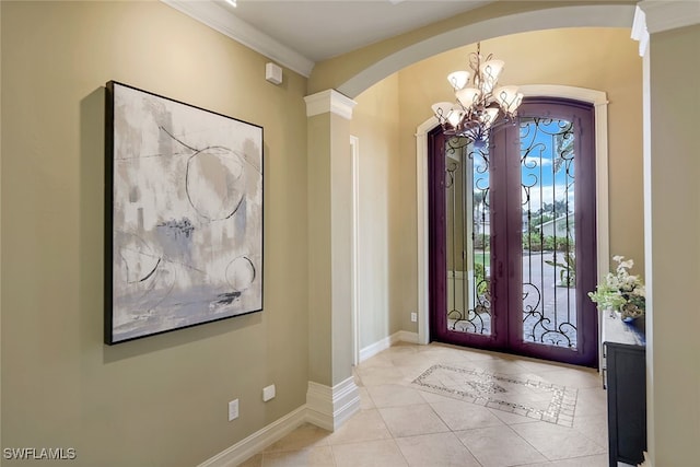 entryway with an inviting chandelier, crown molding, french doors, and light tile patterned flooring