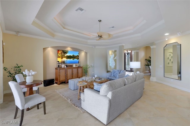 living room with ornate columns, ceiling fan, crown molding, and a tray ceiling