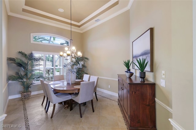 tiled dining area with crown molding, a notable chandelier, and a tray ceiling