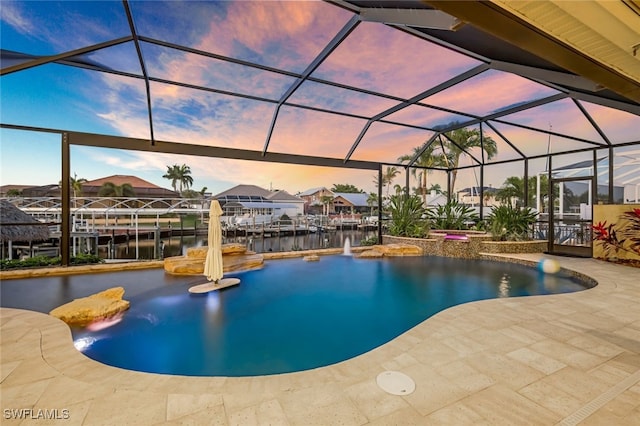 pool at dusk featuring a patio area, a lanai, pool water feature, and a water view