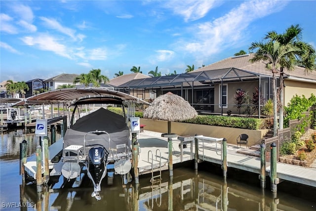 dock area with a lanai and a water view