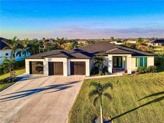 view of front of house with a lawn, a water view, and a garage