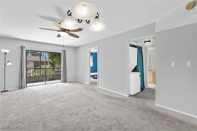 carpeted empty room featuring ceiling fan and stacked washer and dryer