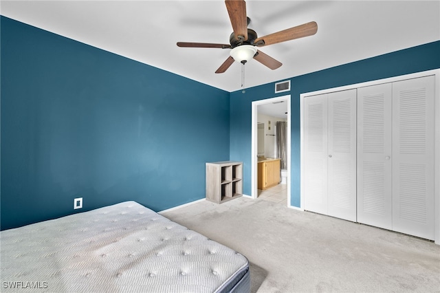 unfurnished bedroom featuring ceiling fan, light carpet, and a closet